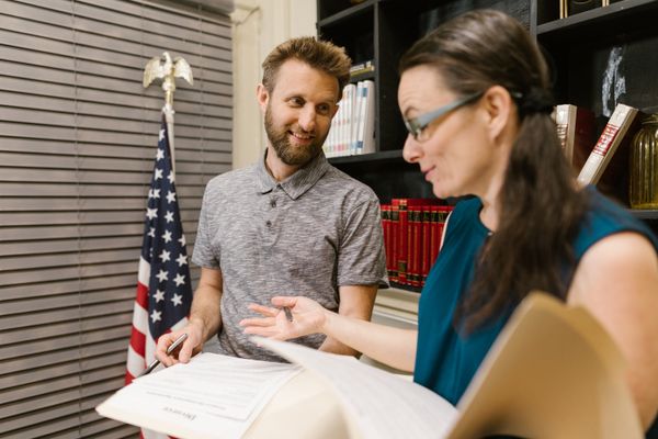 Pareja revisando documentos de inmigración con la bandera de Estados Unidos